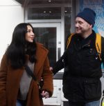 A female member of the public helping a man with sight loss.